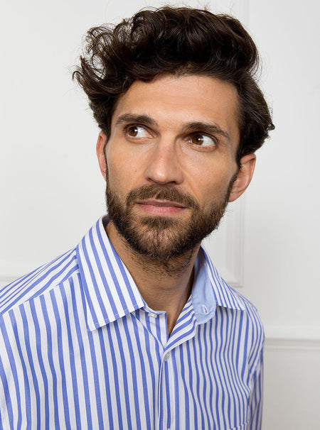 Man wearing long sleeved shirt with royal blue and white stripe. Made with 100% cotton in Thomas Mason fabric.